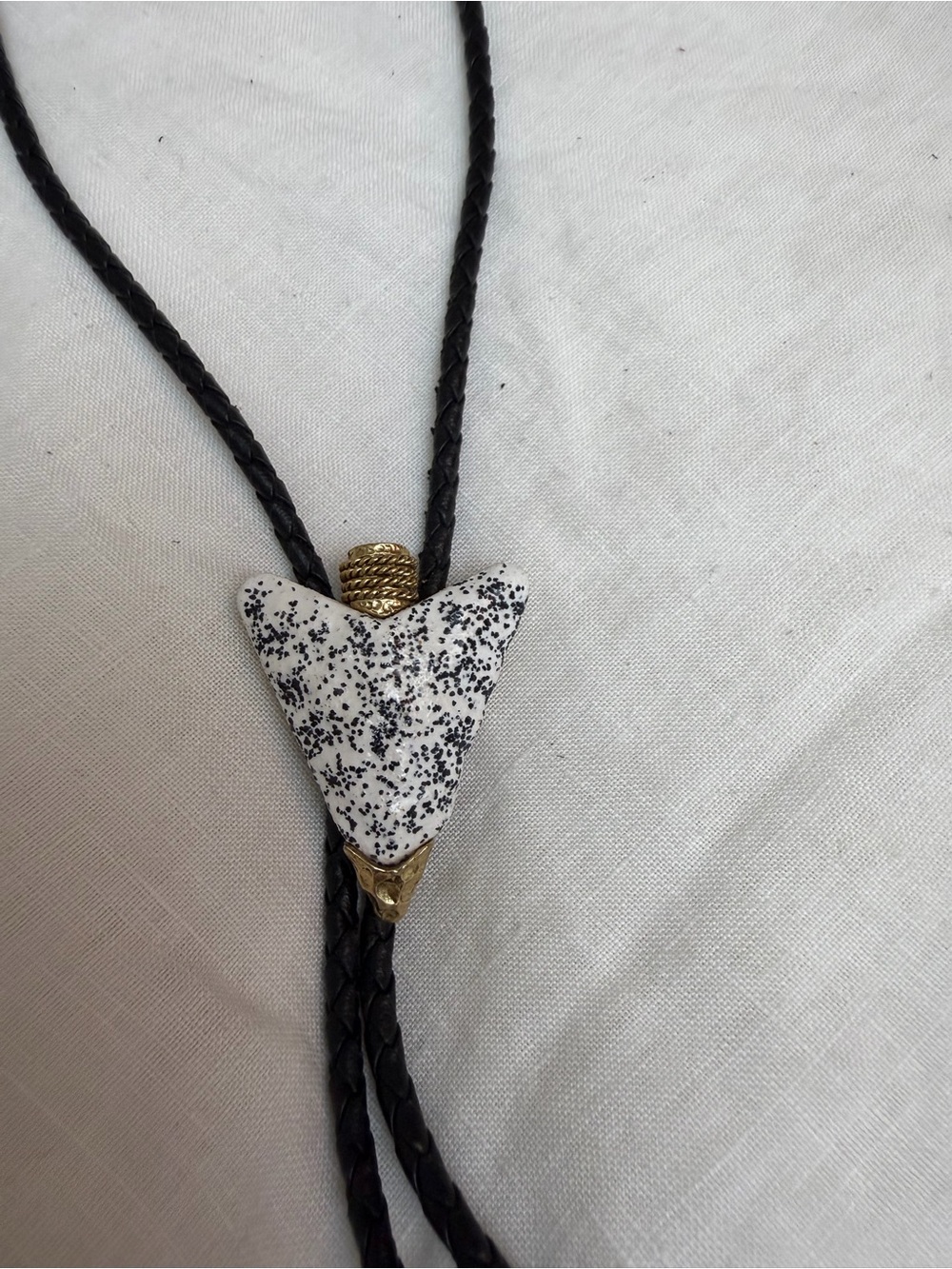 Black Bolo Tie with Speckled White Arrowhead Accent on braided leather rope